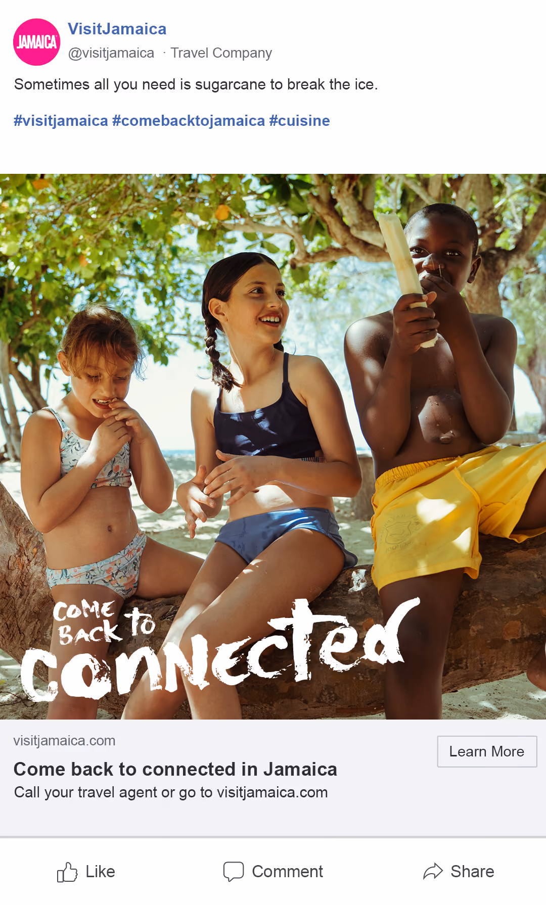 Three children in swimsuits sitting on a tree branch, one boy eating sugarcane, smiling under leafy shade.