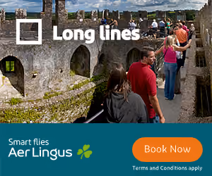 People walking on a stone castle wall with Aer Lingus ad showing 'Long lines' and book now button.