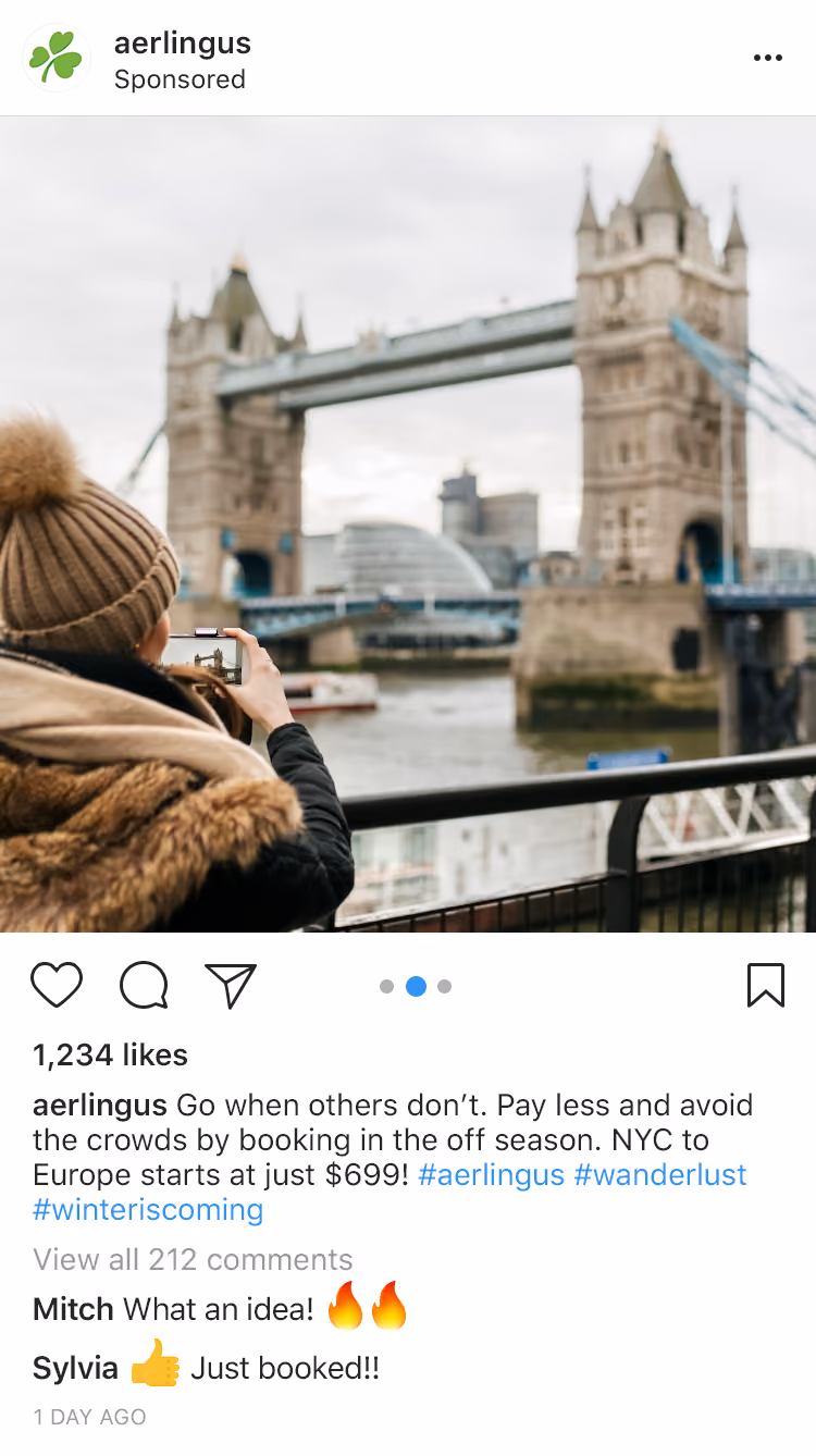 Person in winter coat and hat taking photo of Tower Bridge in London with smartphone.