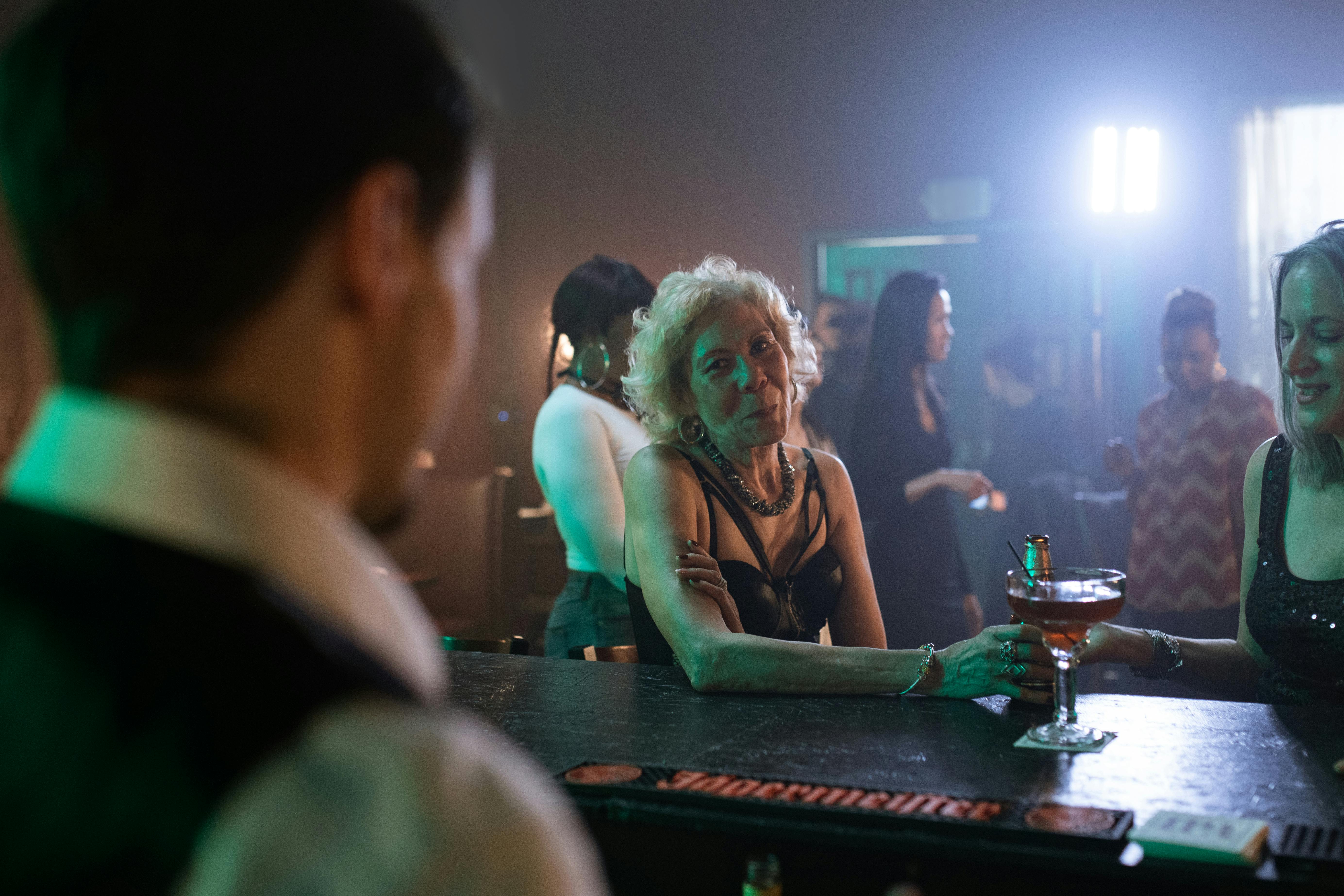 A woman in conversation with the bartender can ignore the party around her for a while