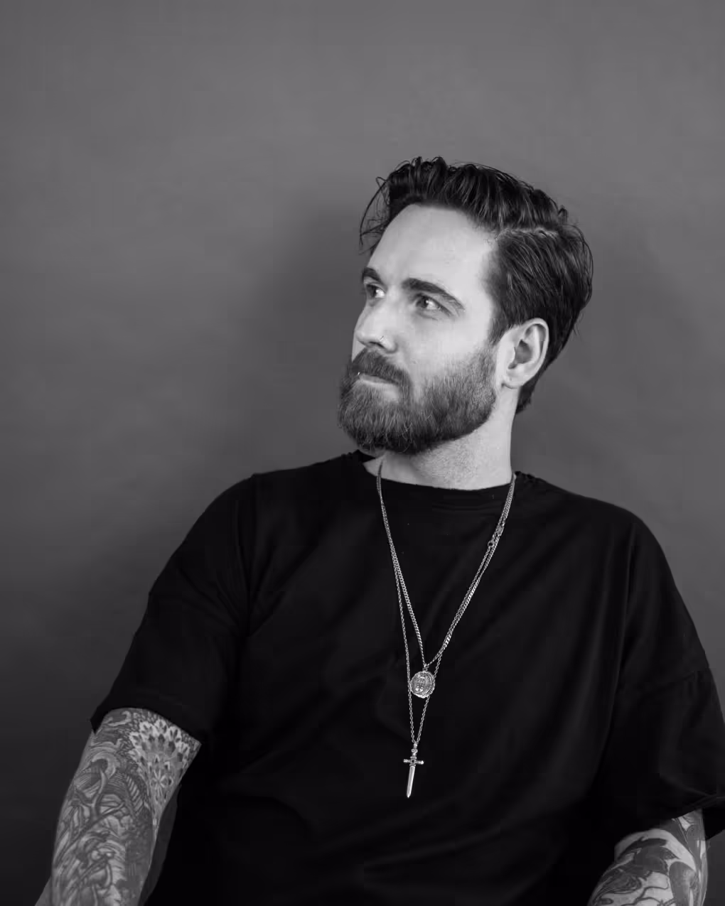 Profile Picture of the Webdesigner and Webflow Developer Jordan Gilroy. He is sitting and looking to the left.