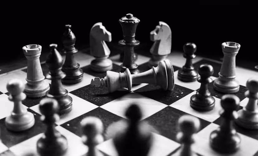 Ein Schwarz-Weiß-Foto eines Schachbretts mit chaotisch verteilten Figuren und einem gefallenen König, symbolisiert eine Website ohne Strategie. upgreight, die Webflow Agentur Südtirol, entwickelt High-End-Websites mit klarem Konzept, um Leads zu generieren, statt nur optisch zu wirken.