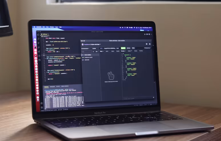 Ein MacBook Pro auf einem Holztisch zeigt die Entwicklung einer Python-API mit Flask in VS Code und das Testen der Routen in einem API-Client.