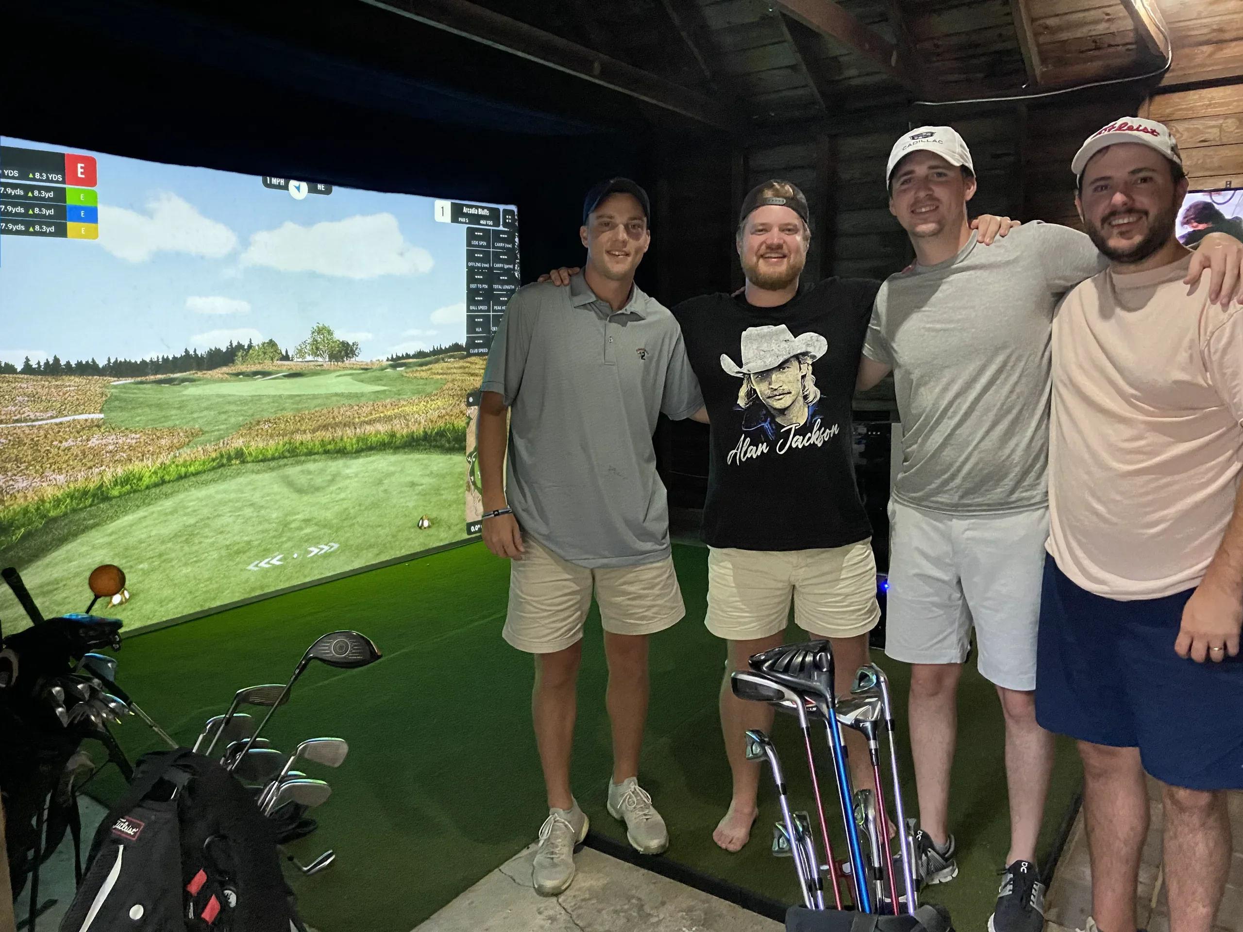 Four buddies in their garage golf simulator