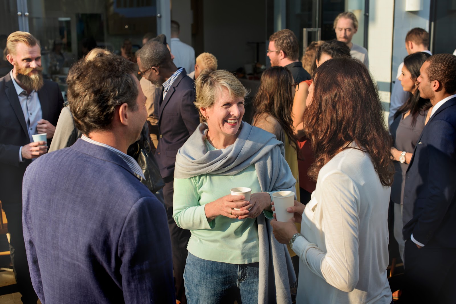 A group of professionals networking and chatting at an outdoor event