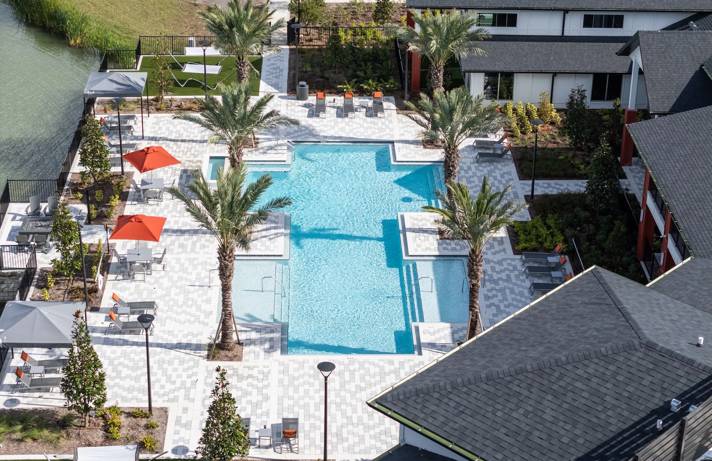 Swimming pool with umbrella and palm trees overhead view 