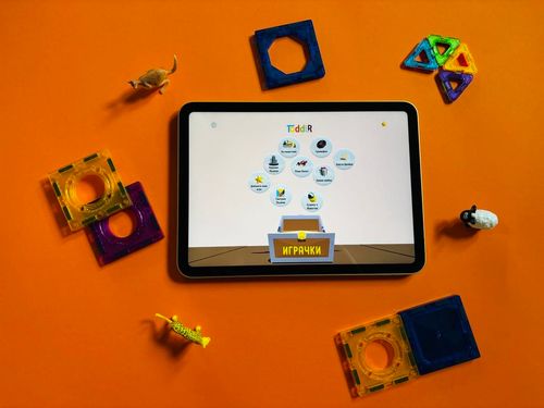Toddlr's Home Screen opened on a table device surrounded by toys