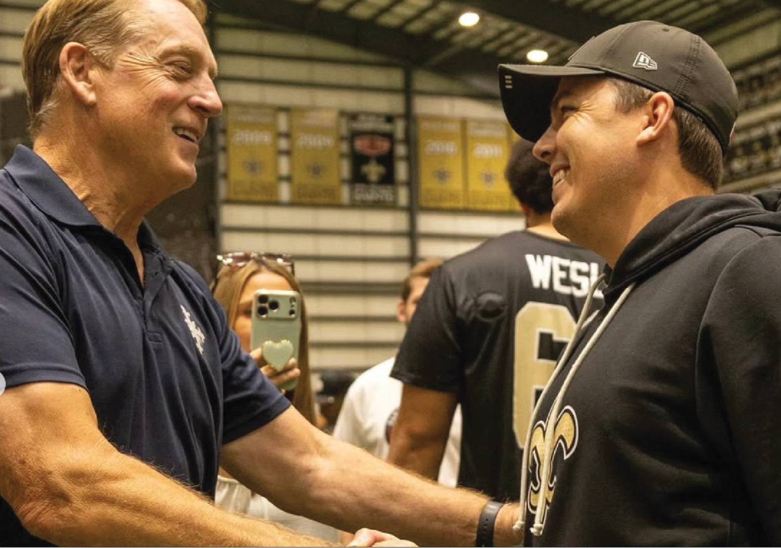 Paris Musketeers and New Orleans Saints coaches greet each other.
