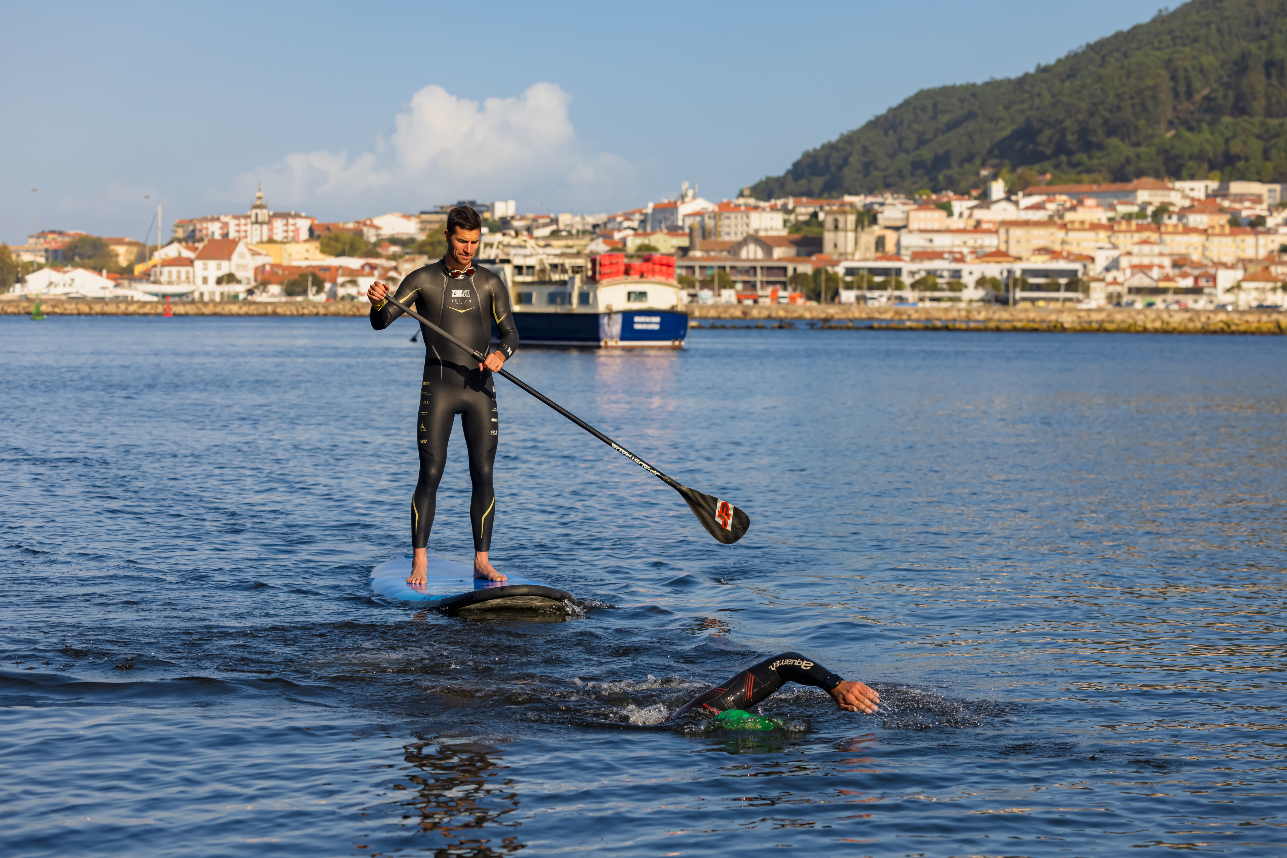 Atelta a nadar e pessoa a acompanhar de padel