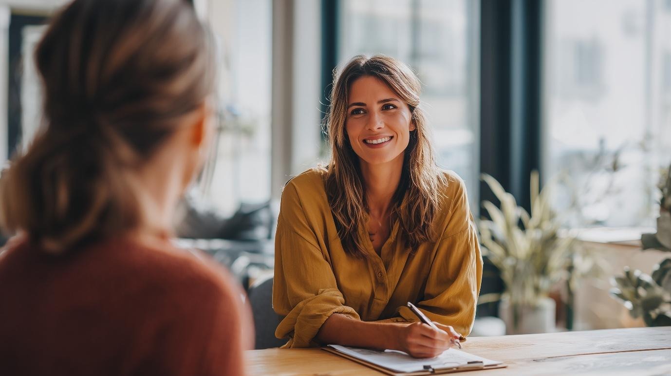 Professional nutritionist smiling while consulting with a client in a bright, modern office, discussing dietary guidance and lactose intolerance support.