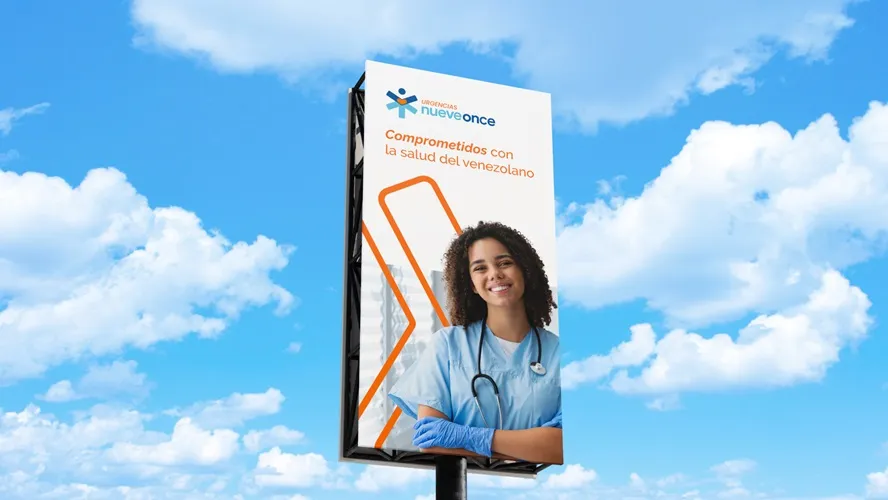 Billboard against a blue sky showing a smiling female healthcare worker in scrubs with a stethoscope and gloves, with text in Spanish about commitment to Venezuelan health.