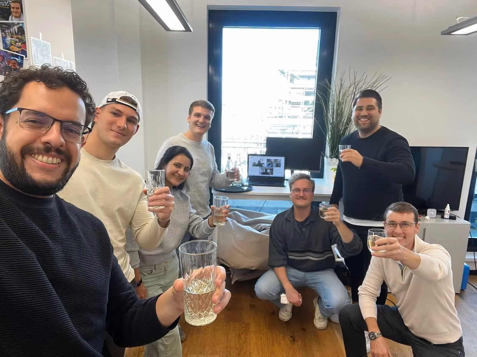 Das Aampere-Team stößt im Büro gemeinsam an