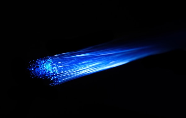 Blue light passing over fibre optic cable. The fiber optic is very vivid and striking. Ideal image for depicting superfast gigabit fibre broadband, networks, networking and other internet technology.