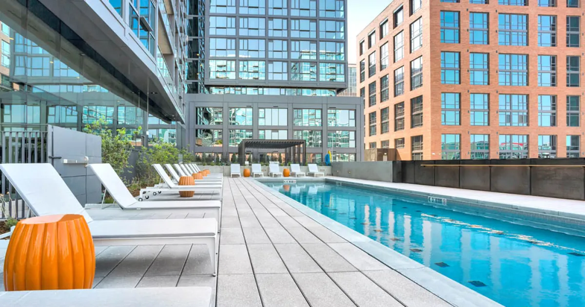 A swimming pool with lounge chairs next to it.