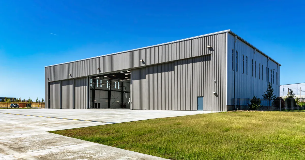 A large industrial building with an open door.