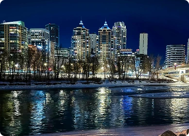 Calgary skyline with the Calgary Tower and the Saddledome arena under clear blue sky.