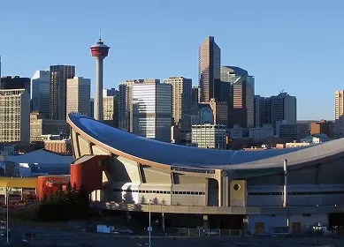 Calgary skyline with the Calgary Tower and the Saddledome arena under clear blue sky.