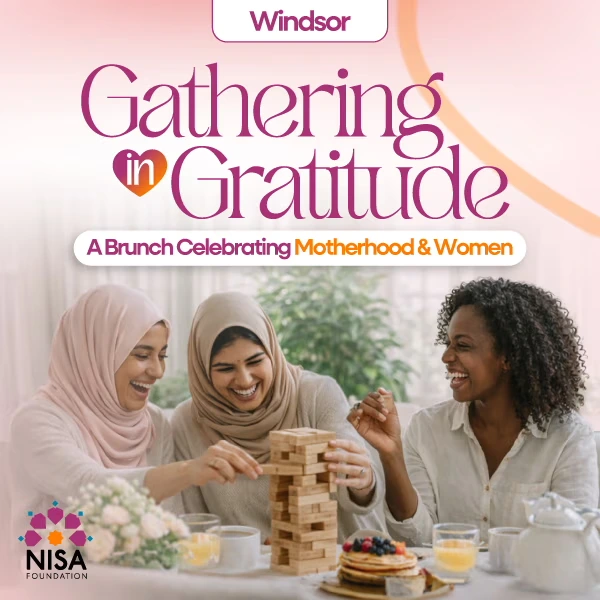 Three women smiling and playing a Jenga game together at a brunch table with pancakes and drinks, promoting a brunch event celebrating motherhood and women in Windsor.