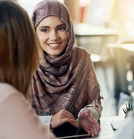 Muslim woman speaking with a support advisor during a community assistance consultation.