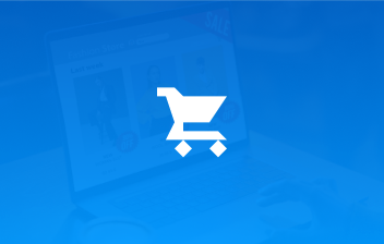 White shopping cart icon over a blurred laptop screen showing an online fashion store.