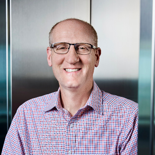 Headshot of a man named Todd Rich wearing glasses and a plaid shirt smiling and staring into the camera. 