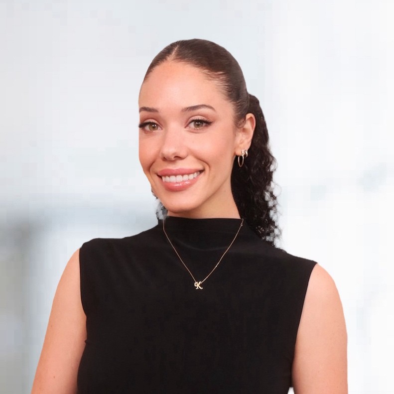 Headshot of a woman named Katherine Carranza wearing a black blouse smiling and staring into the camera.