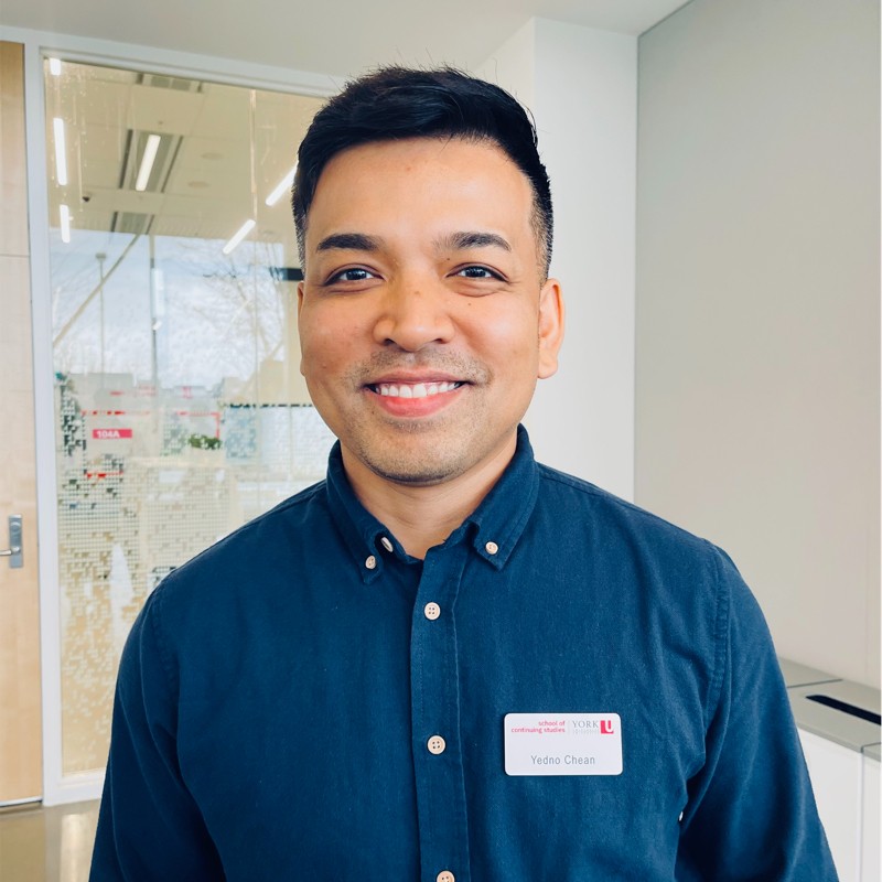Headshot of a man named Yedno Chean wearing a blue corduroy shirt and staring into the camera.