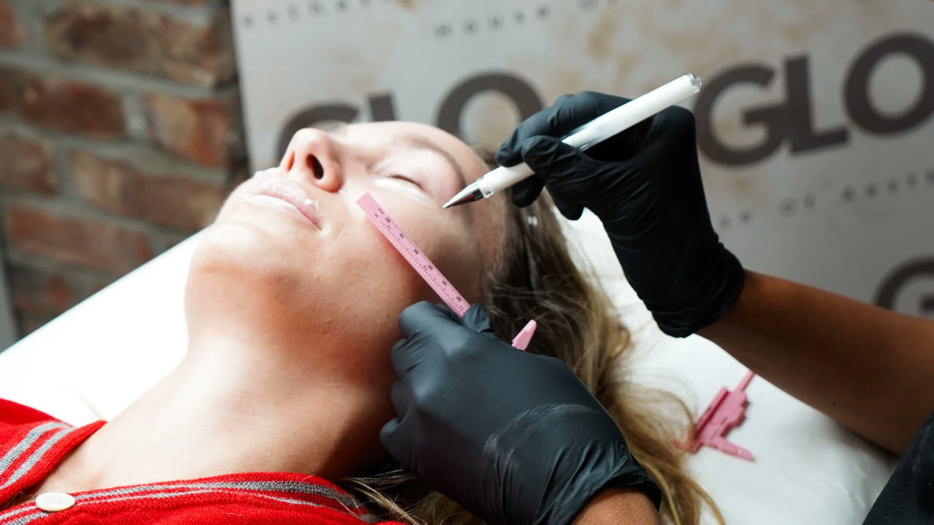 Rosie from GLO using facial measuring tools to assess a client’s cheeks before a polynucleotide treatment.