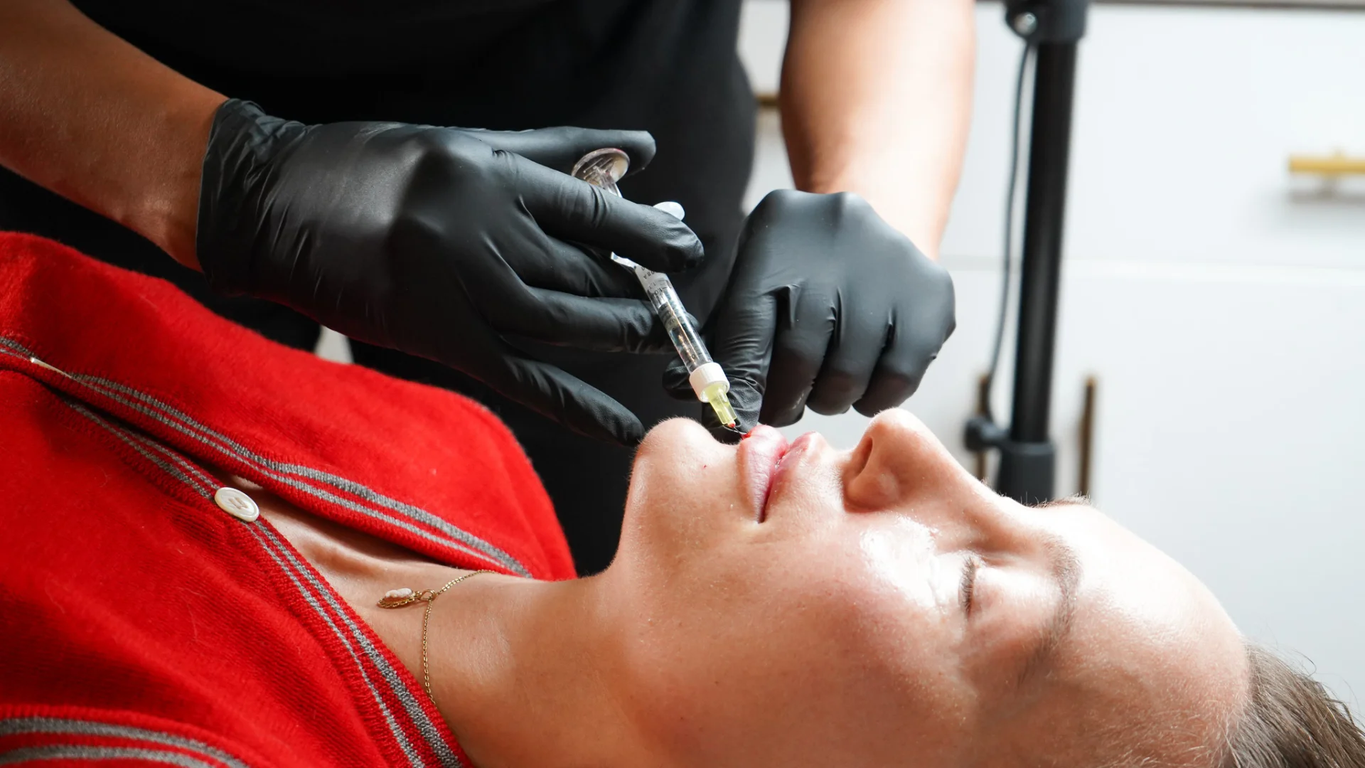 Rosie from GLO carefully administering an injectable treatment around a client’s lips during a skin reset session.