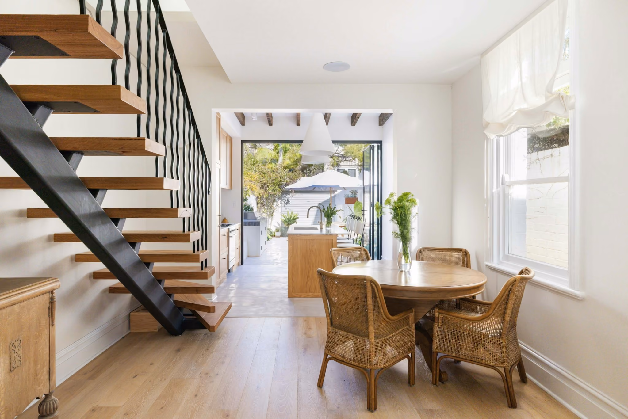Contemporary kitchen extension in Woollahra terrace with oak joinery, marble island and exposed timber ceiling beams opening to courtyard.