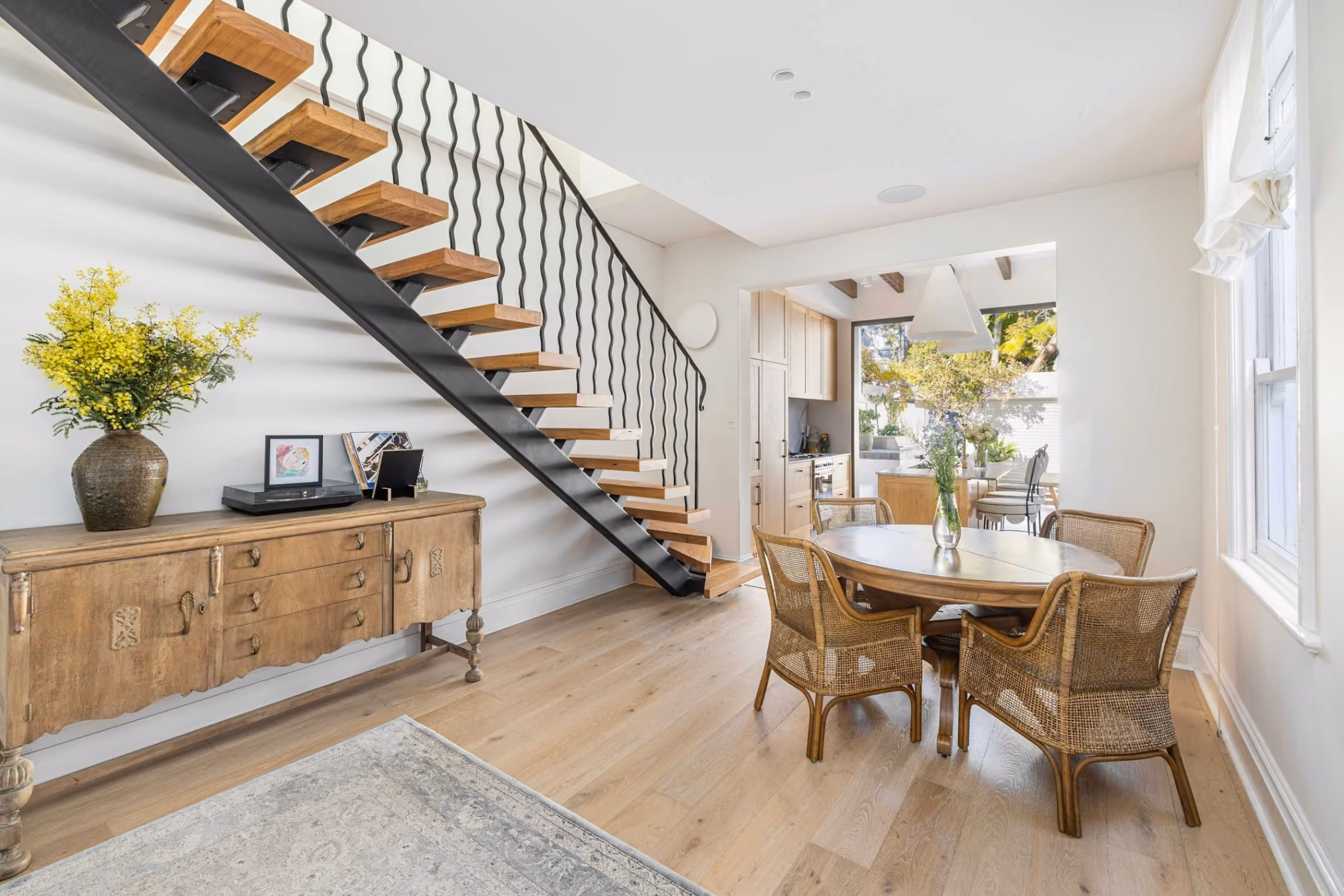 Floating timber stair with sculptural black steel balustrade inside contemporary Woollahra terrace renovation.