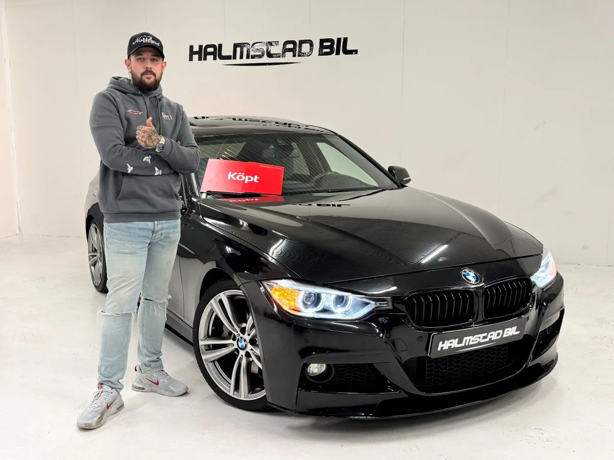 Nöjd kund, står vid sin nyköpta bil hos Halmstad Bil AB.