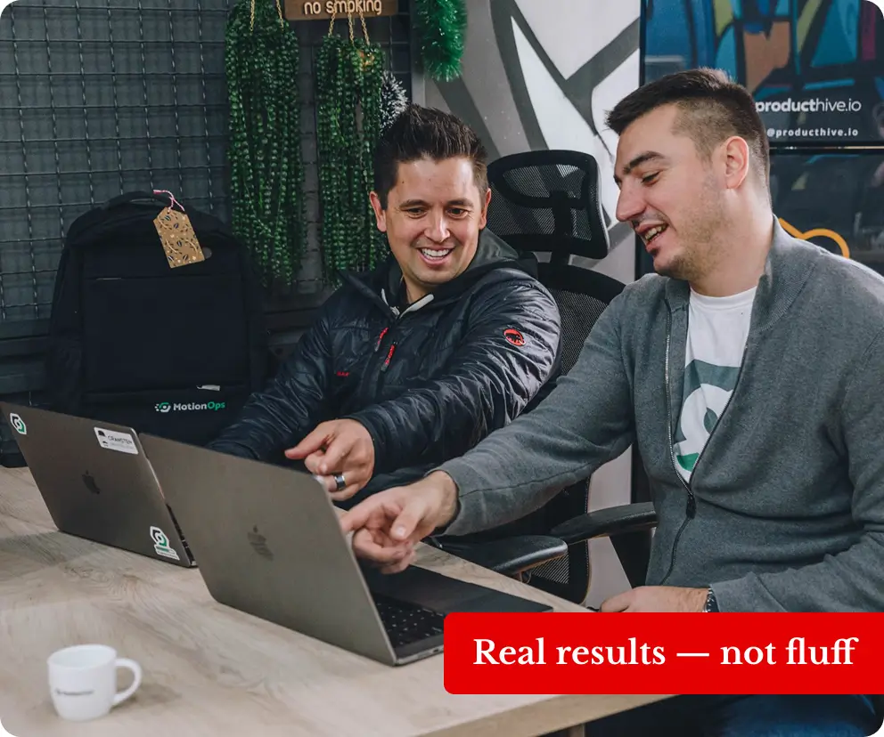 Trevor Maddux and Nikola Cvetkovic working in an office, on their computers, red banner on the image
