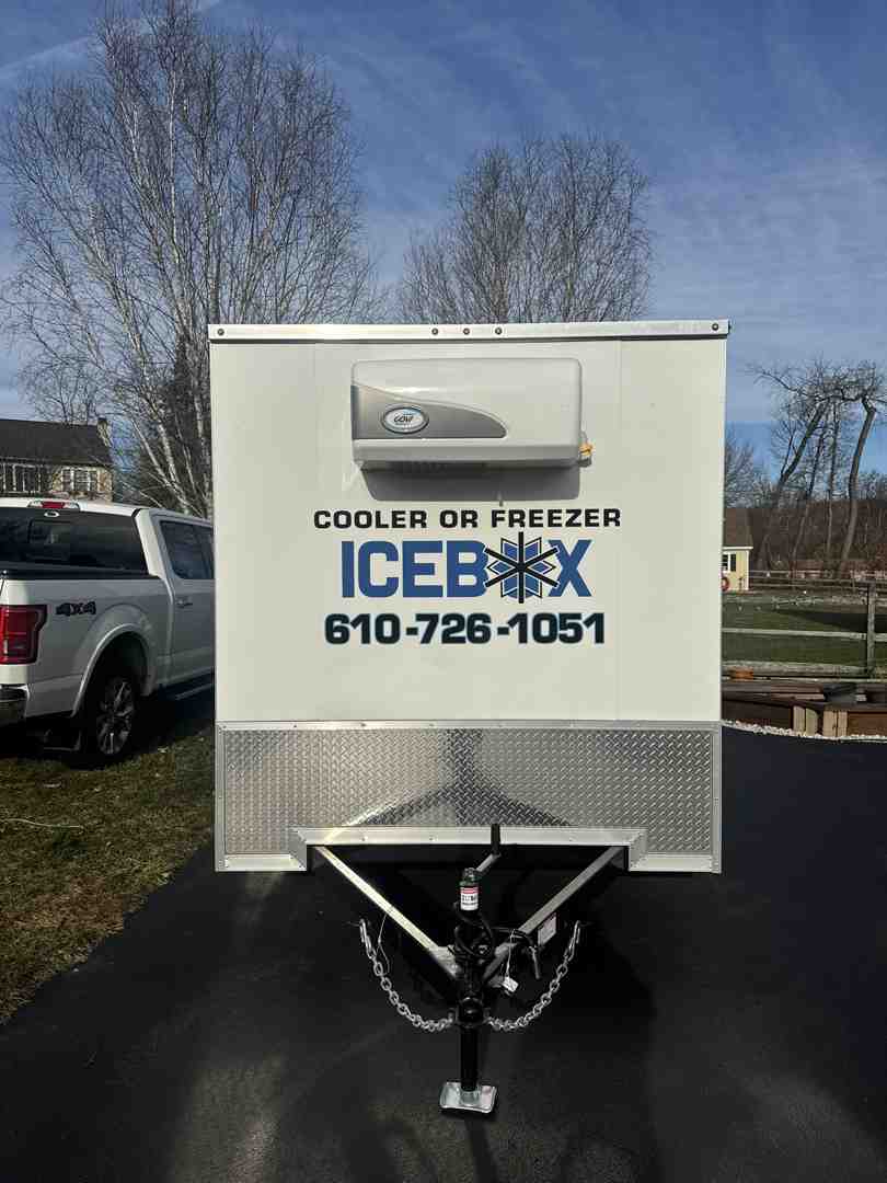 A close-up of a mobile cooler trailer's simple 110V power connection