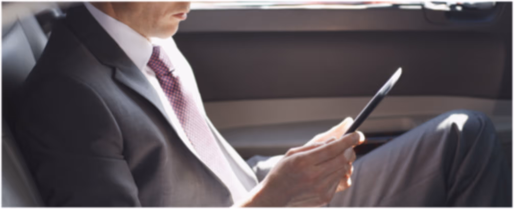 Chauffeur checking trip details on a device before pickup