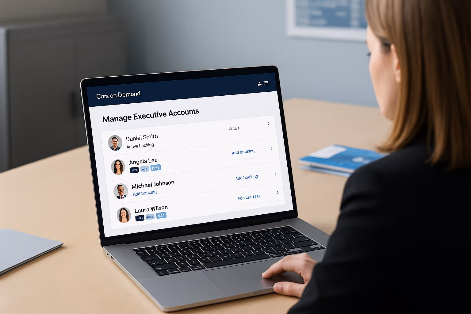Person using a laptop displaying a 'Manage Executive Accounts' page with names, photos, and booking options.