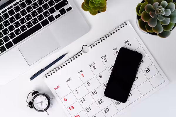 Phone, calendar and laptop on a desk