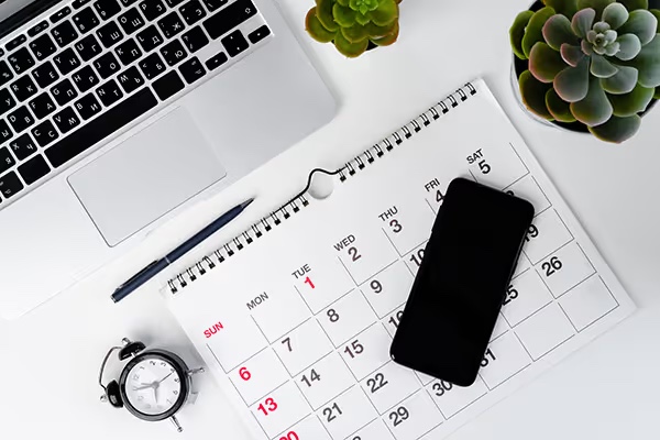 Phone, calendar and laptop on a desk