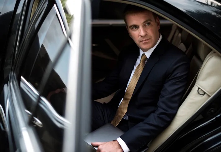 Passenger seated in the back of a chauffeured car