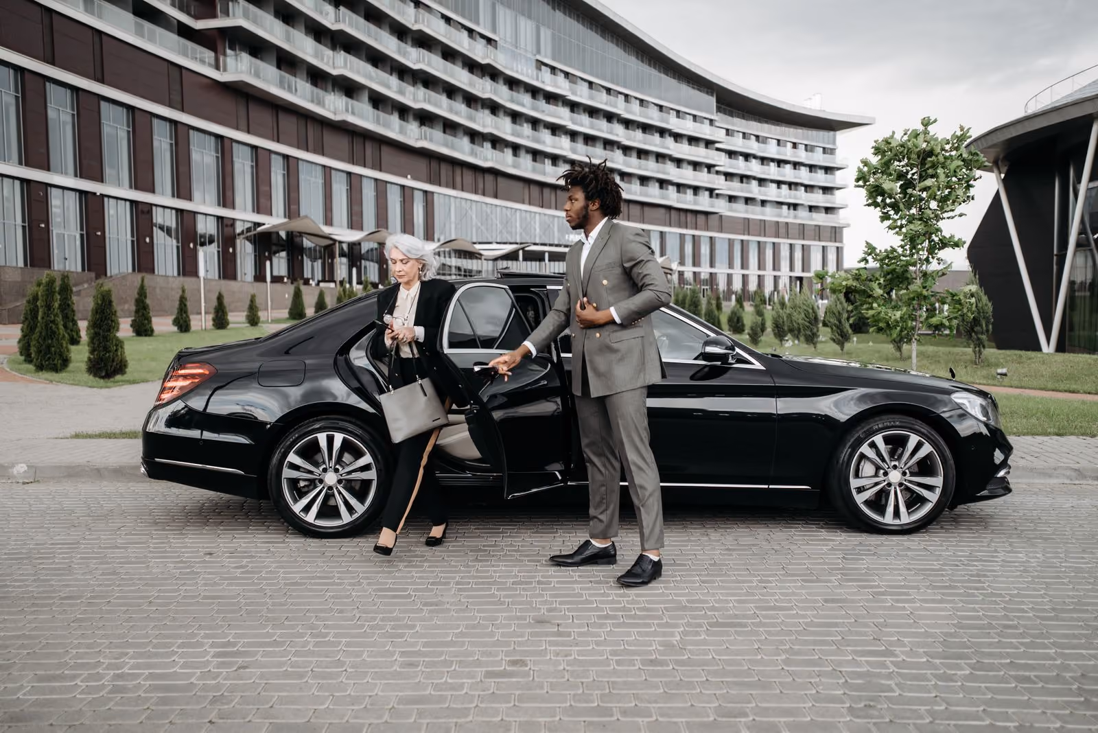 Chauffeur in a suit greeting a business traveller at arrivals