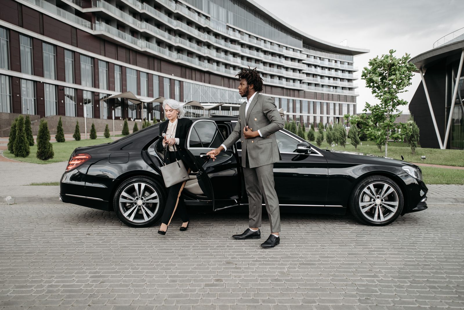 Chauffeur in a suit greeting a business traveller at arrivals