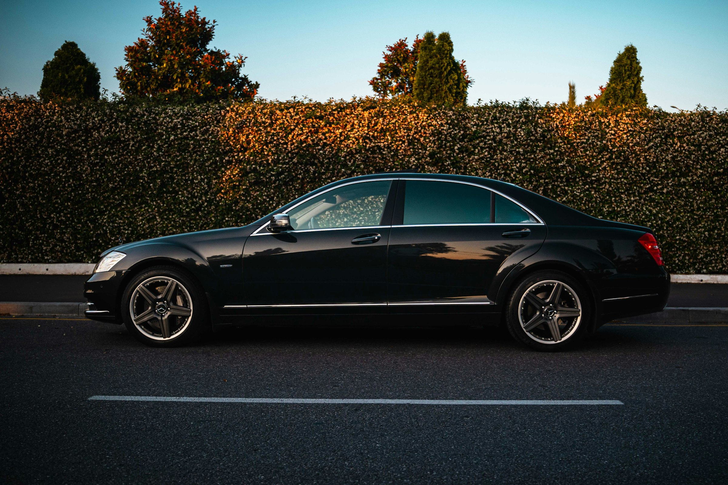 Black chauffeur sedan waiting at Canberra Airport terminal at dusk