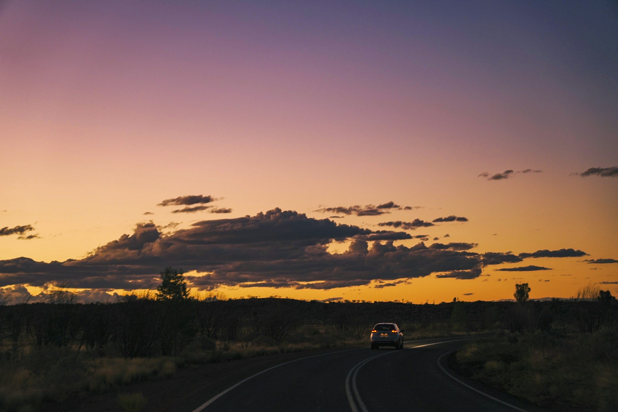 Car on an open Australian highway at golden hour
