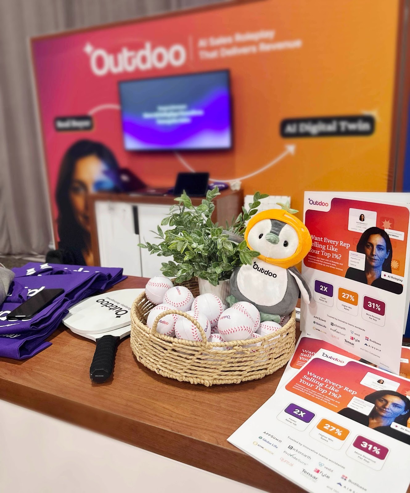 Outdoo AI booth display at Dreamforce 2025 featuring the penguin mascot, marketing materials, and demo setup highlighting AI Sales Roleplay and Digital Twin solutions.