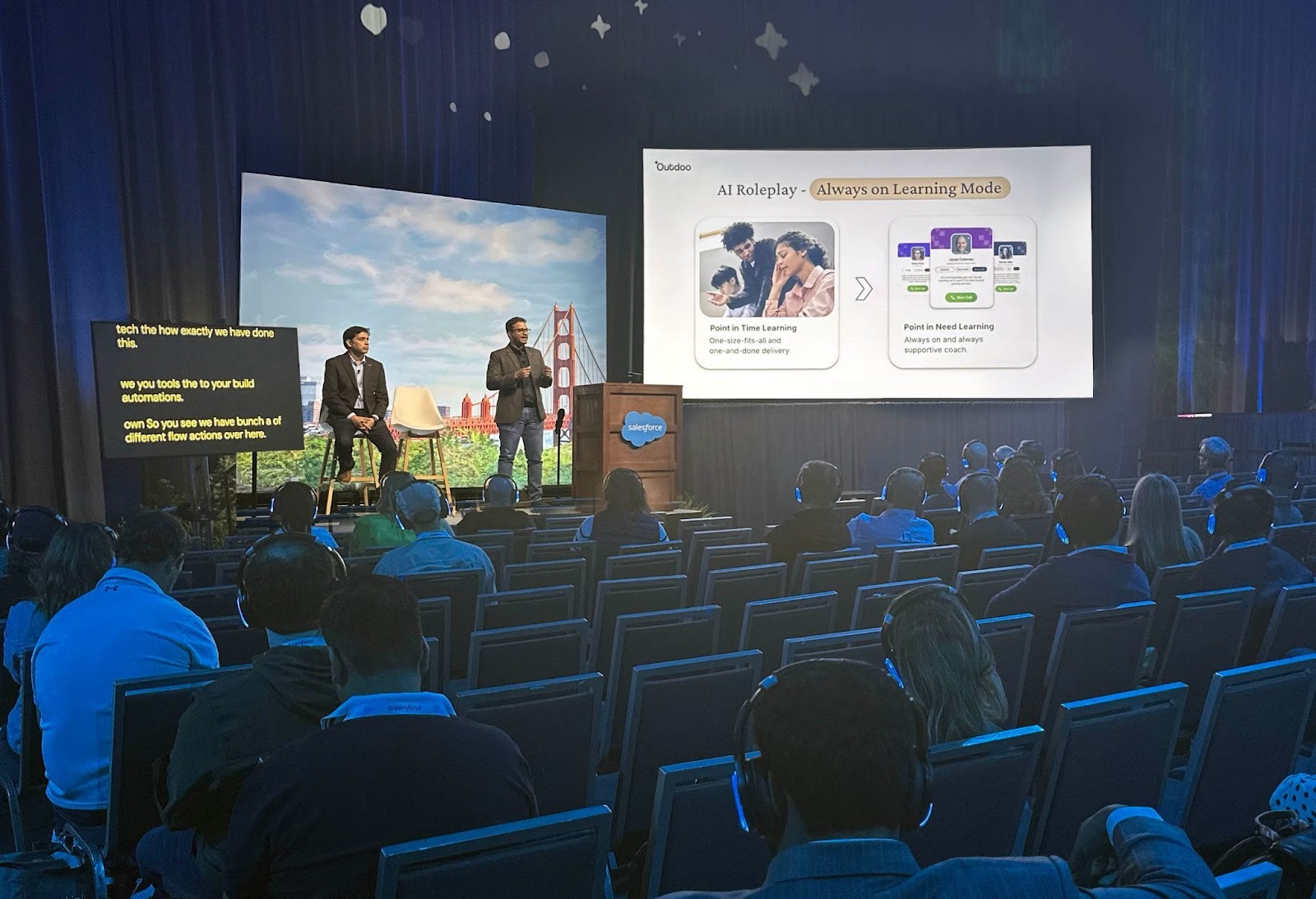 Outdoo AI speaker session at Dreamforce 2025 titled ‘Transforming Sales Coaching with AI,’ showing presenters Snehal Nimje,CEO and Sachin Sinha, CRO on stage discussing AI Roleplays and continuous learning for sales teams.