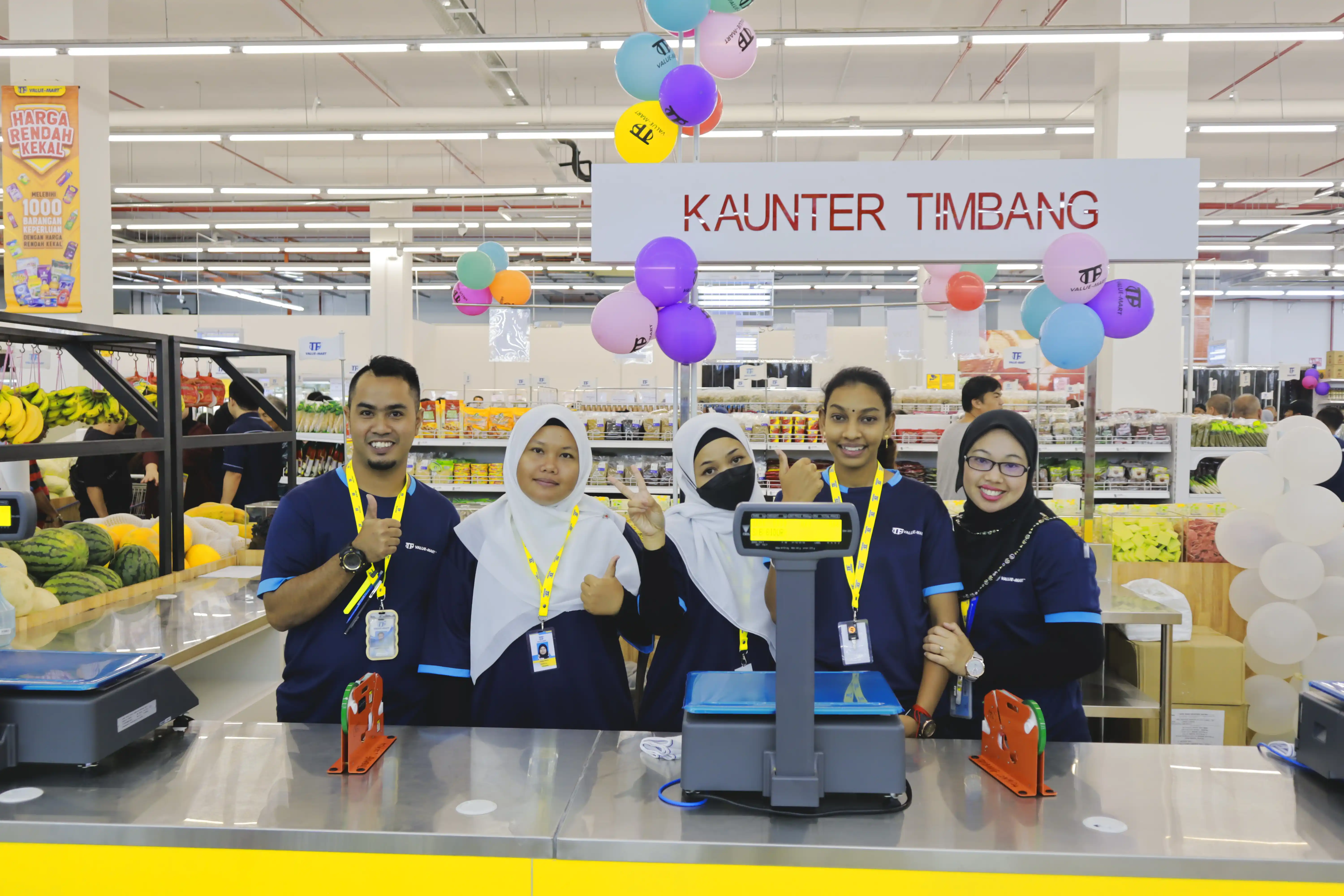TF Value Mart staff standing in a row at a checkout
