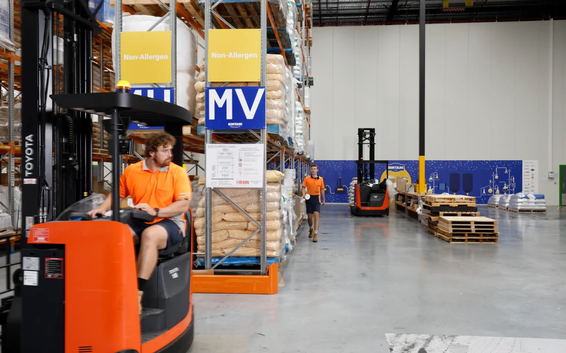 a man driving a forklift in a warehouse