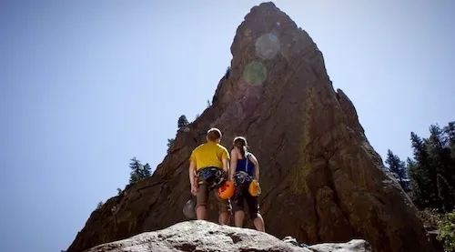 Two hikers looking at the peak of a mountain