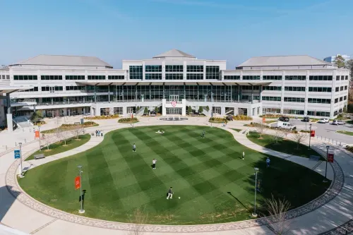 Highlands college campus view with students playing on a grass field