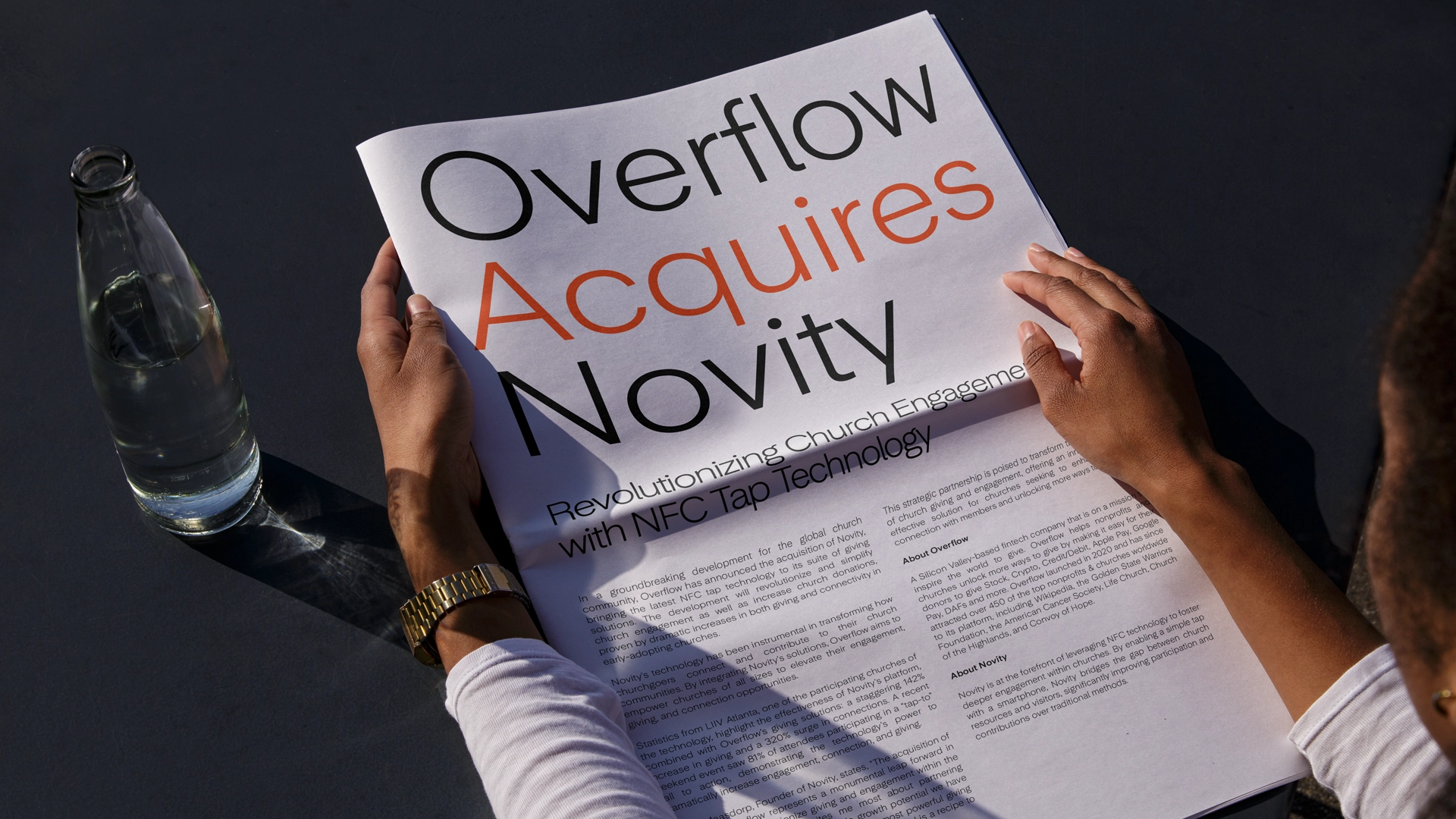 Woman holding a newspaper that reads "Overflow Acquires Novity"